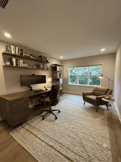 A restyled home office with timber furniture, a rug and a reading chair